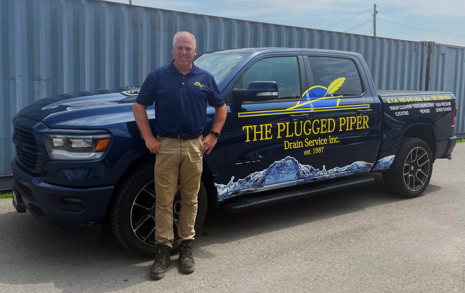 The Plugged Piper owner beside a branded service truck